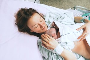 Mutter haelt Neugeborenes direkt nach der Geburt