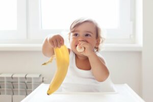 ein baby mit 1 jahr isst eine banane