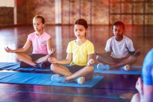 Kinder machen Yoga in einer Gruppe