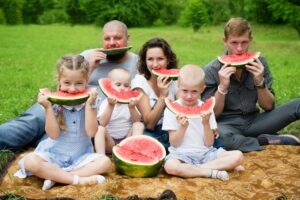 Familie im Park isst Wassermelone