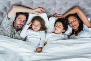 glückliche Familie schläft zusammen im Bett