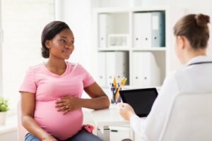 schwangere Frau im Gespräch mit einer Ärztin