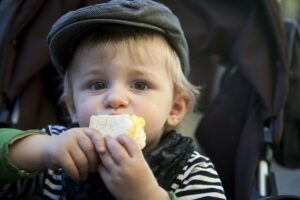 ein Kind hält ein Stück Brot in der Hand