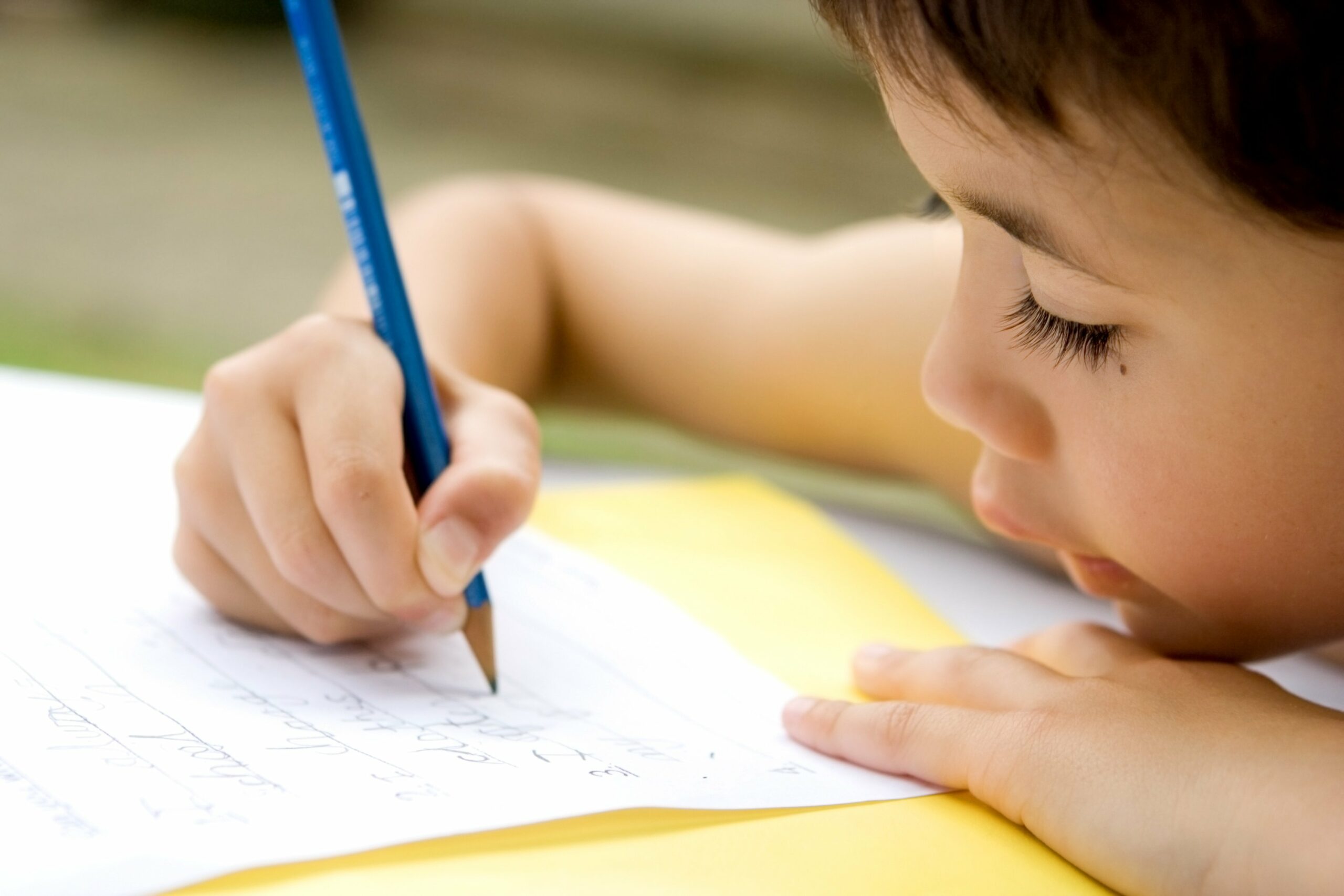 Kind schreibt auf Papier